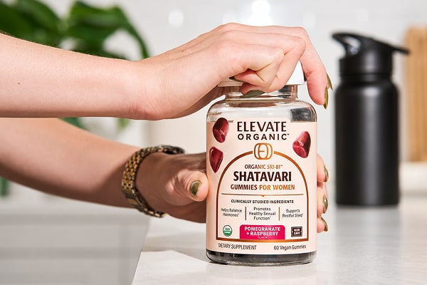 Hand opening a bottle of Shatavari gummies